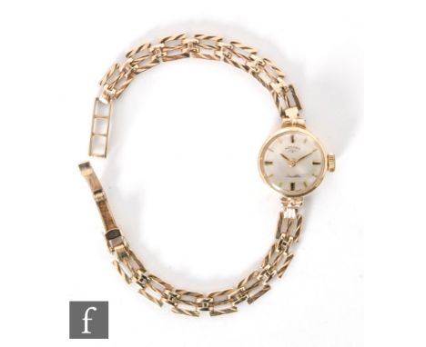 A 9ct hallmarked ladies manual wind ladies wrist watch, batons to a circular silvered dial and 9ct gate link bracelet, total 