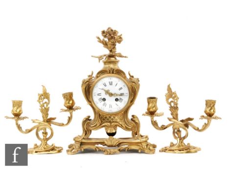 A late 19th to early 20th Century French gilt metal clock garniture, stamped A.G. Mougin, the clock with a foliate finial abo