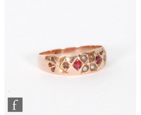 A 9ct rose gold ruby and seed pearl gypsy set eight stone ring, Chester 1895, ring size S. 