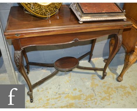 An Edwardian mahogany fold-over card table, with a shaped apron above acanthus carved cabriole legs united by a stretcher she