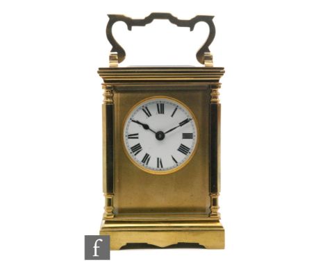 An early 20th Century brass carriage clock, Roman numerals to a circular white enamelled dial, raised on bracket feet below s