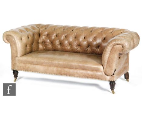 A Victorian drop arm Chesterfield sofa or settee, upholstered in button down taupe coloured leather over turned and tapered f