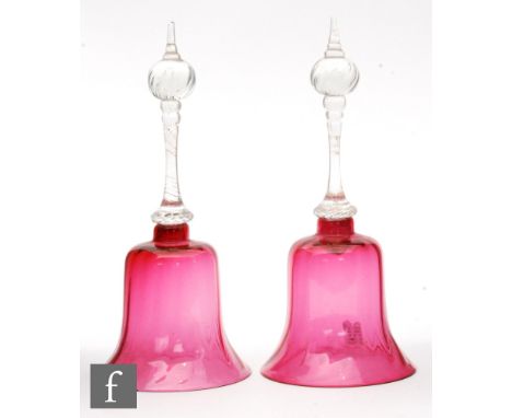 A pair of 19th Century ruby glass table bells with optic moulded bodies and clear glass twisted handles, height 23.5cm. (2)