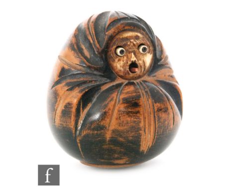 A Japanese Daruma netsuke, Meiji/Taisho period, the carved wooden body applied with a carved ivory inlaid face, with protrudi