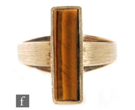 A 9ct hallmarked tigers eye ring, rectangular collar set panel to a matte finished shank, ring size P, London 1973.