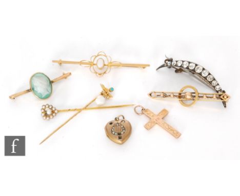 A small parcel lot of jewellery to include four brooches, two stick pins, a 9ct cross and a small heart shaped pendant. (8).