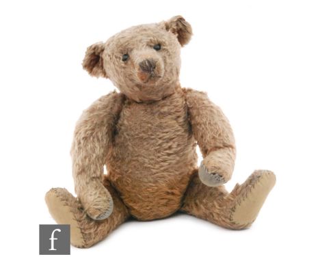 An early 20th Century teddy bear, possibly Steiff, circa 1910, with dark golden brown mohair, black boot eyes, muzzle, brown 