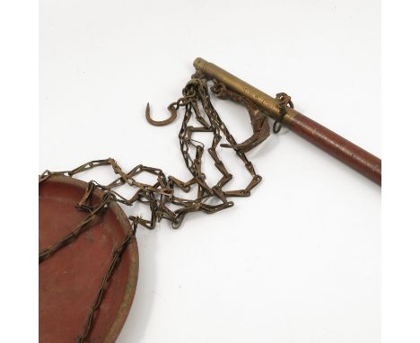 An Oriental single pan scale, the copper pan suspended on chains, supported on a mahogany and brass stick with pin head decor