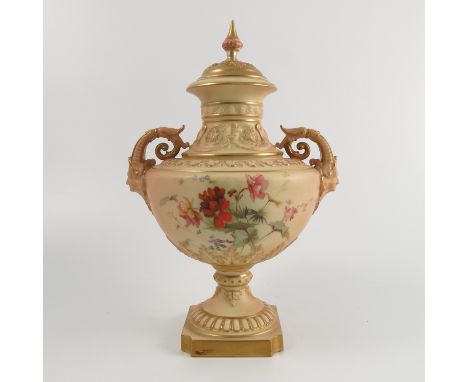 A Royal Worcester blush ivory covered pedestal vase, with mask and scroll handles, moulded neck, the body decorated with flow