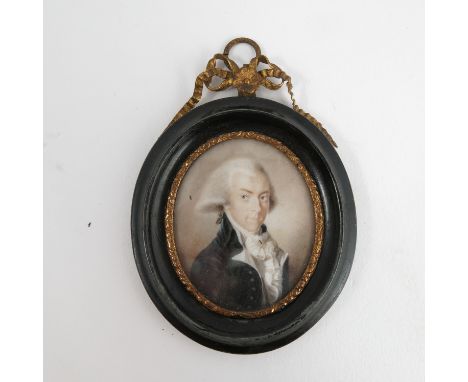 An oval portrait miniature, of a man in period dress, in an ebonised and gilt metal frame, maximum diameter of portrait 2.25i