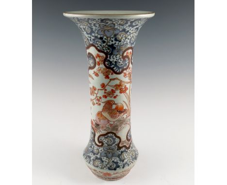 A Chinese Imari trumpet shaped vase, decorated with birds in iron reds to a blue scroll ground, height 6.75ins Condition repo