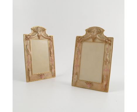 A pair of Royal Worcester blush ivory menu holders, of shaped rectangular form, embossed with a frame of fruit and dead game,