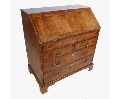 A Georgian walnut bureau, the cross and feather banded top opening to reveal a fitted interior with secret drawers, cupboard,