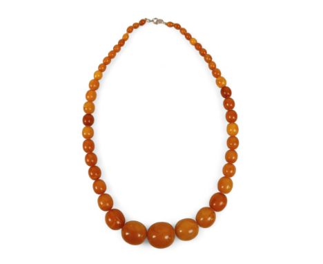 A butterscotch amber bead necklace, with bolt ring clasp, of forty five graduating beads, largest bead 24 by 27.3mm, 60cm lon