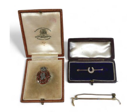 Three gold brooches, comprising a platinum 15ct yellow gold riding crop (6cm long), a diamond horseshoe brooch and a Victoria