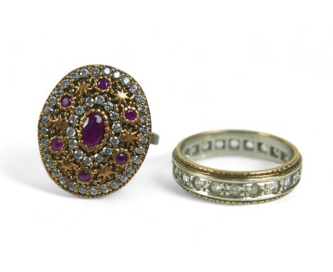 A ruby and clear stone ring, the oval and round-cut rubies alternating with rings of clear stones and gilt metal stars on 925