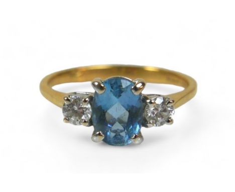 An 18ct gold blue topaz and diamond ring, the oval cut blue stone, 4 by 7mm, size K/L, 2.6g. 