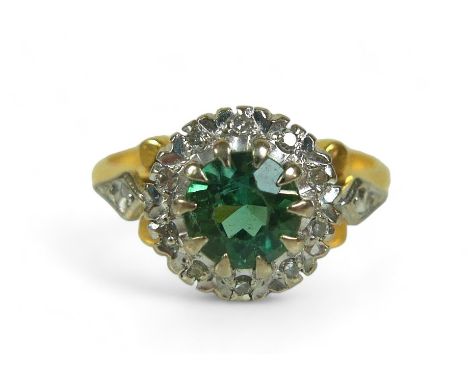 A diamond and green stone flowerhead cluster ring, possibly green tourmaline, the round-cut central stone surrounded by small