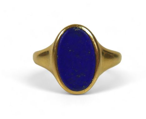 A George V 18ct gold and lapis lazuli signet ring, with flat oval central stone, 12 by 7mm, London 1926, size J, 4.9g.