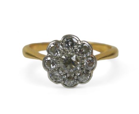 An 18ct gold diamond daisy ring, the central round cut diamond 3mm diameter, surrounded by eight smaller round cut diamonds, 