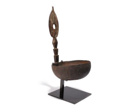 An Admiralty Islands ladle Papua New Guinea coconut shell, gum and carved wood, 29.5cm high, on a stand. (2)