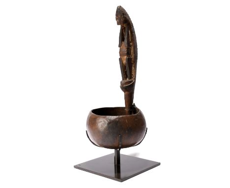 An Admiralty Islands ceremonial ladle Melanesia coconut, wood, nut paste and pigment, the handle carved as a figure with a cu