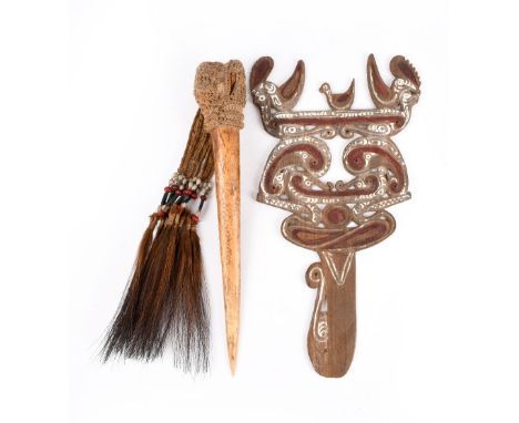 An Asmat cassowary bone dagger Irian Jaya, Indonesia with fibre, beads and feathers, 37cm long, and a Massim wave splitter or