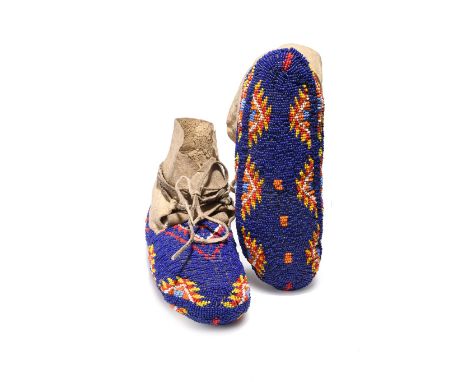 A pair of Sioux fully beaded moccasins Plains hide with dark and light blue, red, white, orange and yellow glass bead decorat