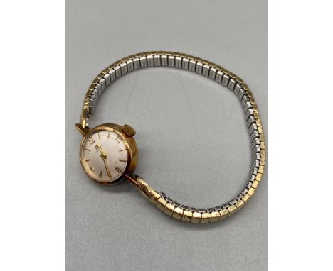 A 9ct gold cased 'Tissot' ladies 17 Jewels watch with a plated flexible wrist band. In a running condition. 