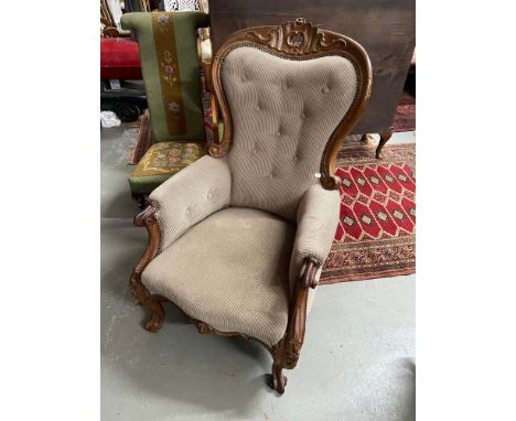 A 19th century mahogany carved ornate frame library/ fireside chair. Designed with a button back and arm rests. 