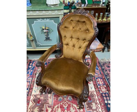 A 19th century library arm chair designed with button back area. Wooden frame shows various detailed carvings. 