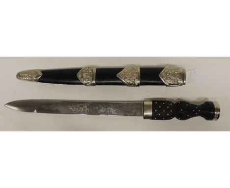 A reproduction Scottish dirk with metal studded carved wood grip, the blade etched with thistles and scrolling foliage and in