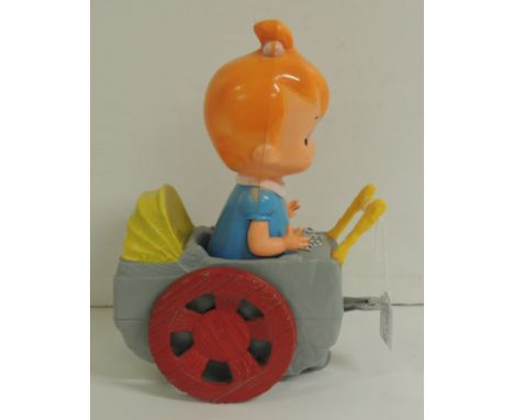 A vintage plastic clockwork musical Pebbles in a pram 27cms high