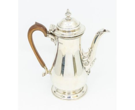 A Georgian style silver pear shaped coffee pot, plain body acanthus detail to spout, domed cover with urn shaped finial, frui