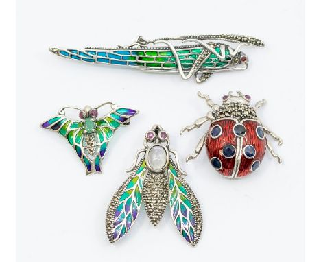 A collection of silver and enamel brooches, mostly plique a jour, to include a lady bird with red enamel and sapphire set dot