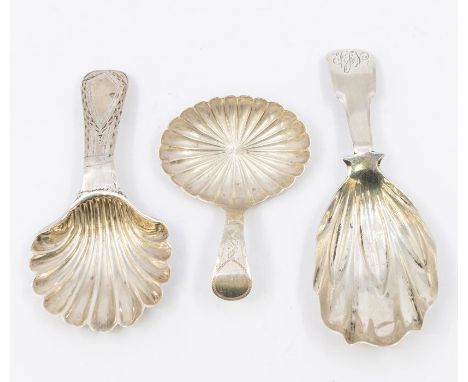 A collection of three early 19th Century silver caddy spoons, each with stylised shell shaped bowl, two with bright-cut engra