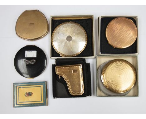 A collection of seven compacts, four in the original boxes, including a piano design compact