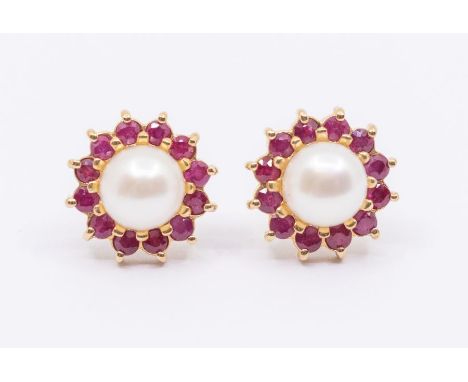 A pair of pearl and ruby 9ct gold stud earrings comprising a white button pearl to the centre within a border of claw set rou