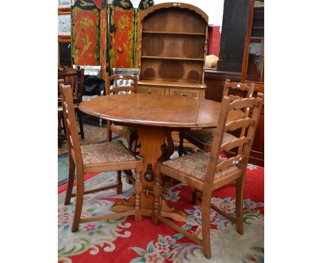 A Priory light oak domed top dresser, drop leaf table and four ladder back chairs