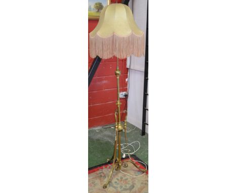An early 20th century brass standard lamp, the central column knopped throughout with girdles and terminating in a globular r
