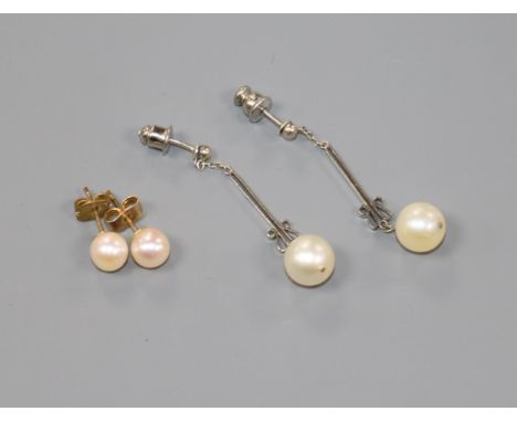 Two pairs of cultured pearl earrings including white metal drop earrings.