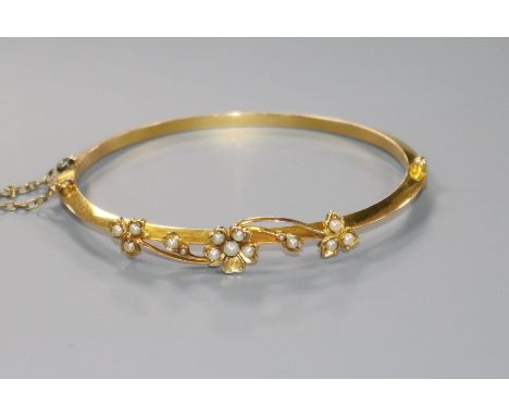 An Edwardian 15ct gold and seed pearl set hinged bracelet.