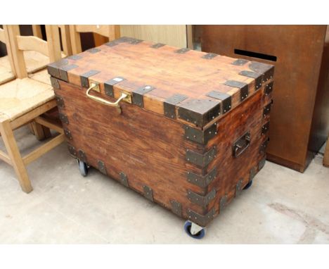 A PINE TRUNK WITH METAL STRAPS AND BRASS HANDLE ON WHEELS, 36" X 20" 