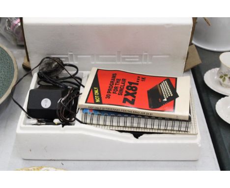 A VINTAGE SINCLAIR ZX81 COMPUTER WITH POWER SUPPLY AND PROGRAMMES IN ORIGINAL BOX 