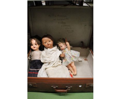 A VINTAGE LEATHER SUITCASE CONTAINING THREE VINTAGE DOLLS 