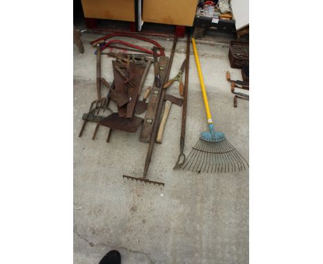 AN ASSORTMENT OF GARDEN TOOLS TO INCLUDE A SHOVEL, FORK AND RAKES ETC 