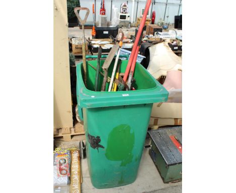 A WHELIE BIN WITH AN ASSORTMENT OF TOOLS TO INCLUDE SHEARS AND SPADES ETC 