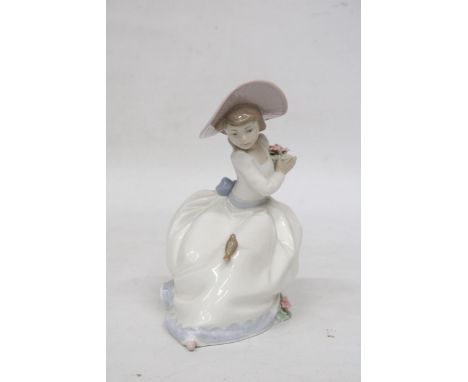 A NAO FIGURE OF A SEATED GIRL WITH FLOWERS AND A BIRD ON HER DRESS 