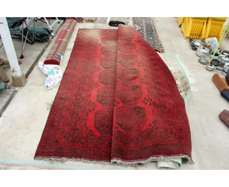 A LARGE VINTAGE RED PATTERNED FRINGED RUG 