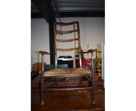 A traditional stained frame rush seated ladder back carver chair